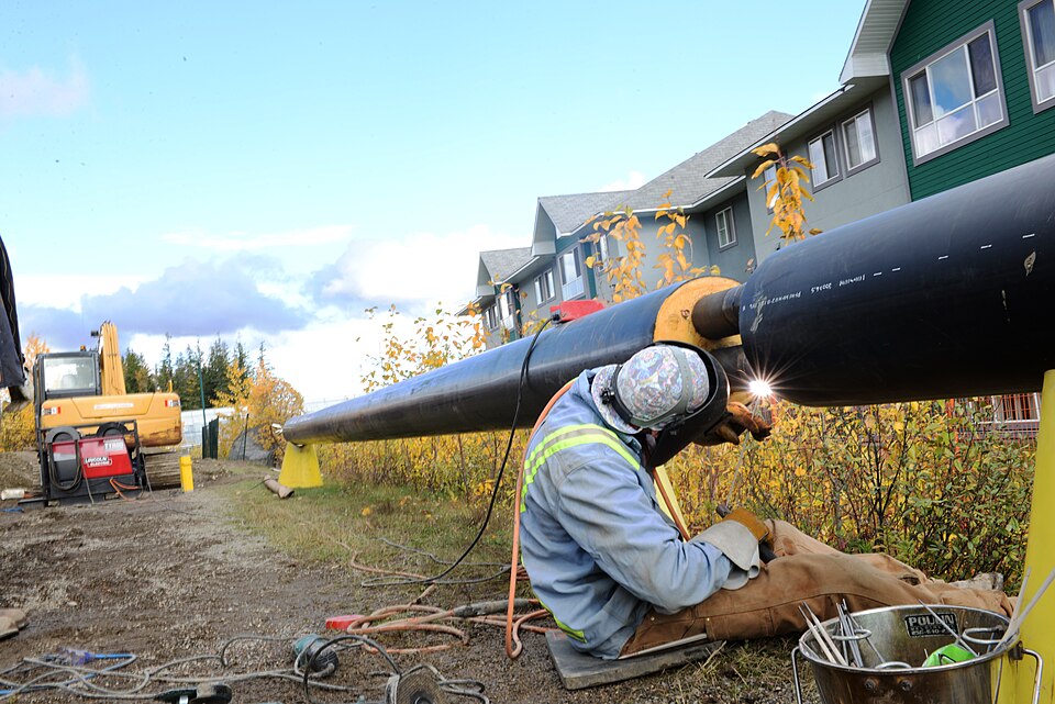 Welder joining a large steel pipe